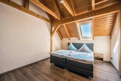 a bedroom with a bed in a room with a wooden ceiling at Susis Ferienwohnungen in Braunsroda