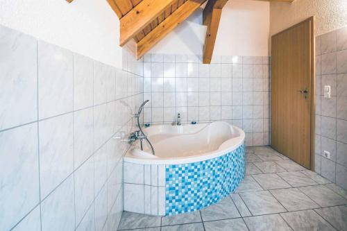 a bathroom with a bath tub in a tiled room at Susis Ferienwohnungen in Braunsroda