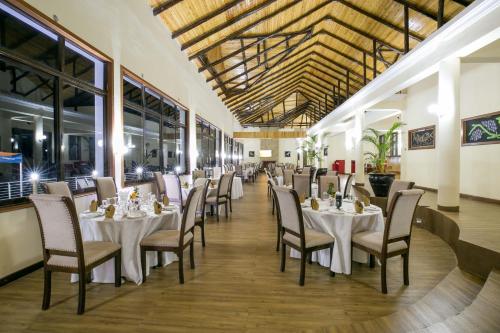 a dining room with white tables and chairs at Lake Elementaita Mountain Lodge in Nakuru
