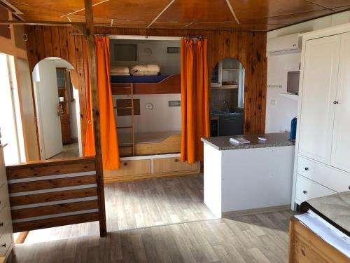eine Küche mit orangefarbenen Vorhängen und einer Theke in einem Zimmer in der Unterkunft Bungalow Ostseeblick in Insel Poel
