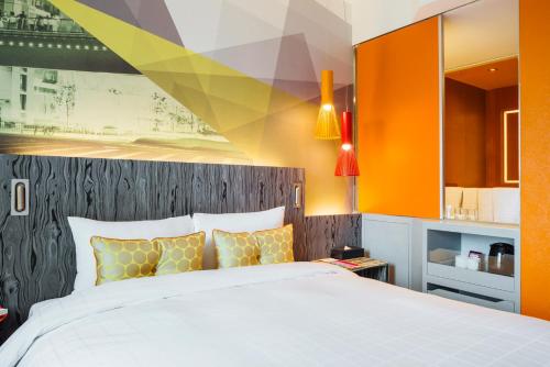 a bedroom with a large bed and orange walls at Ibis Styles Ambassador Seoul Gangnam in Seoul