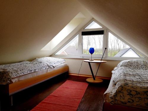 um quarto no sótão com 2 camas e uma janela em STHS79005-FeWo-Meerruschen em Meeschendorf
