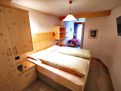 a bedroom with two beds and a cabinet in it at Garni Gabrieli in Corvara in Badia