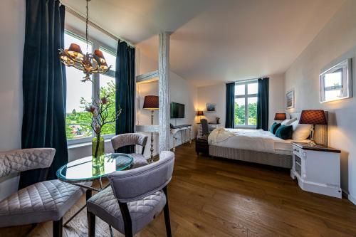 - une chambre avec un lit, une table et des chaises dans l'établissement VILLA TAEGERMOOS, à Tägerwilen