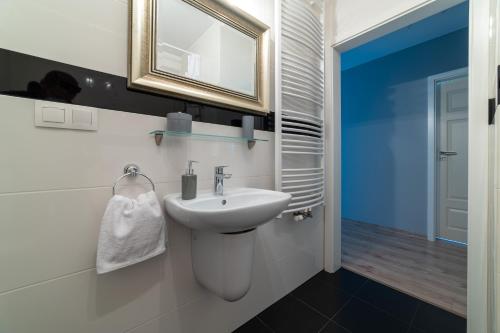 a bathroom with a sink and a mirror at Nautical Sea Apartment in Gdynia