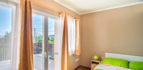 a bedroom with a bed and a large window at Berkes Vendégház in Badacsonytördemic