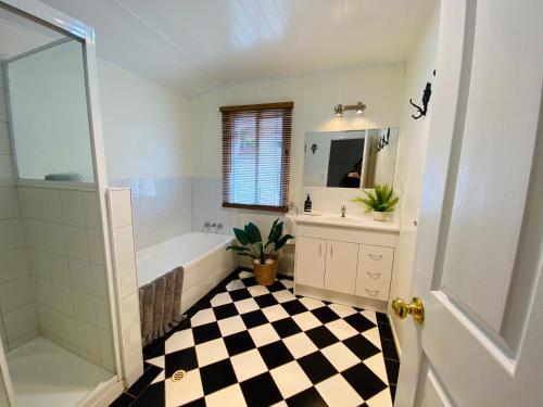 a bathroom with a black and white checkered floor at Ashbrooke Cottage in Toowoomba