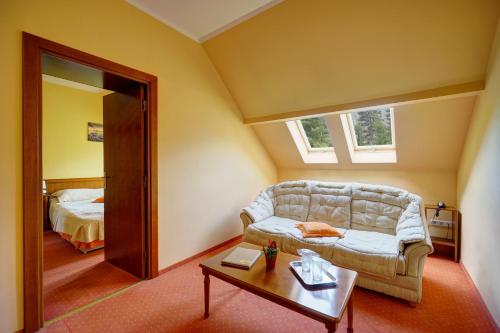 a living room with a couch and a table at Hotel Ciucas in Băile Tuşnad