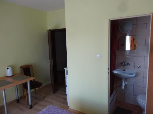 a bathroom with a sink and a toilet and a table at Ośrodek Korab in Władysławowo