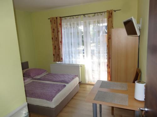 a bedroom with a bed and a table and a window at Ośrodek Korab in Władysławowo