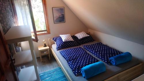 1 dormitorio con 1 cama con almohadas azules y blancas en Relax II. Vendégház, en Dunapataj