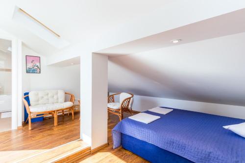 una camera con letto e sedie di Apartman Aqua-Juric a Crikvenica
