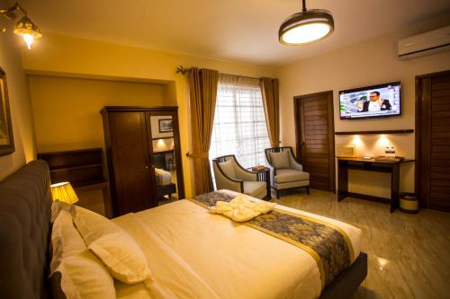 a hotel room with a bed and a tv at Shinepukur Suites in Dhaka
