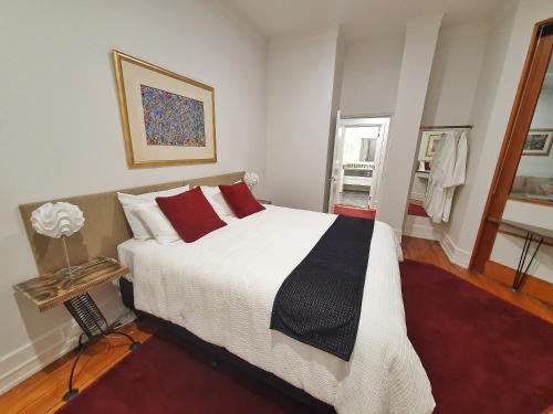 1 dormitorio con 1 cama grande con almohadas rojas en Heritage 313 Auckland, en Auckland