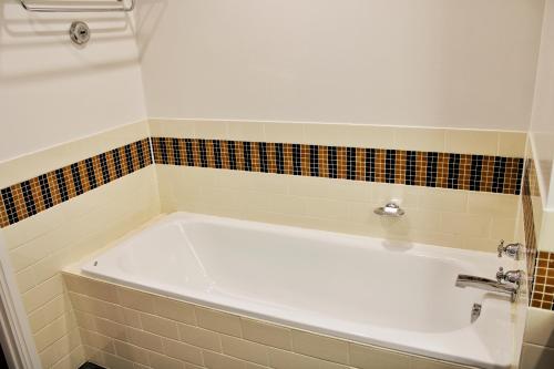 y baño alicatado con bañera blanca. en Heritage 313 Auckland, en Auckland