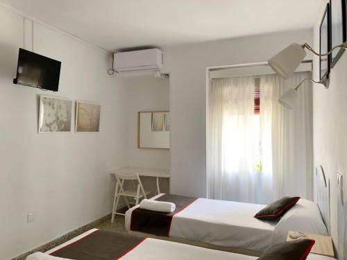 a hotel room with two beds and a window at Hostal Paco Marbella in Marbella