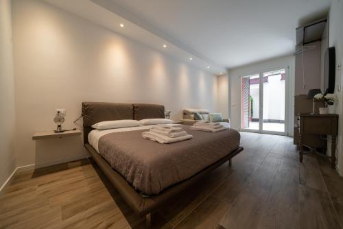 een slaapkamer met een bed met handdoeken erop bij Smart House S.Orsola - Garage & Garden in Bologna