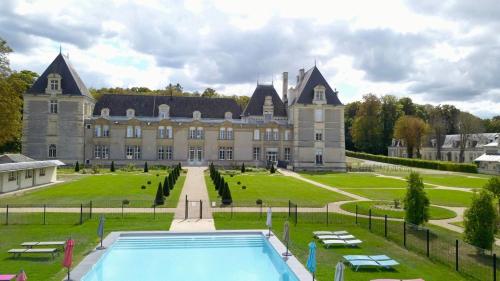 un grand château avec une piscine en face dans l'établissement Chateau De Jalesnes, à Vernantes