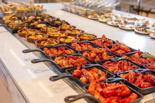a buffet with many trays of food on a table at RVHotels Ametlla Mar in L'Ametlla de Mar