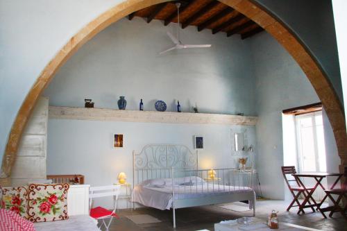 a bedroom with a bed and an archway at Aperanti Agrotourism in Pera Orinis