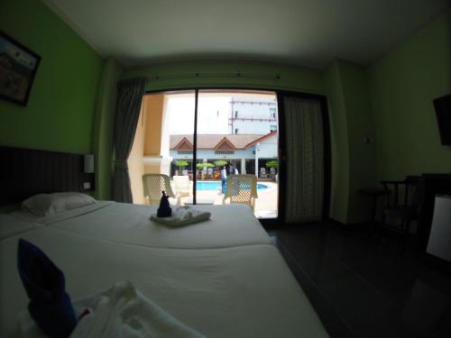 een slaapkamer met een bed en een groot raam bij Jed Pee Nong Hotel โรงแรมเจ็ดพี่น้อง in Hua Hin