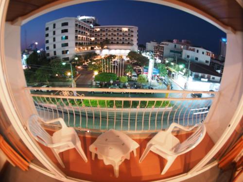een raam met uitzicht op de stad 's nachts bij Jed Pee Nong Hotel โรงแรมเจ็ดพี่น้อง in Hua Hin