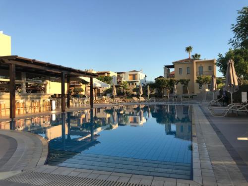una piscina in un resort con tavoli e sedie di Vagia Mare a Gerani Chanion