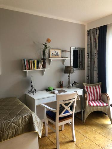 a bedroom with a desk with a bed and a chair at Ankerplatz Binz im Haus Strelasund in Binz
