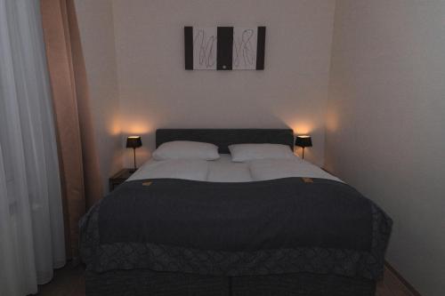 a bedroom with a large bed with two lamps at Pension a und a in Vienna