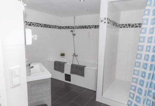 a white bathroom with a tub and a sink at Pension a und a in Vienna