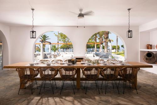 una sala da pranzo con un grande tavolo in legno e sedie di Kassandra Palace Seaside Resort a Kriopigi