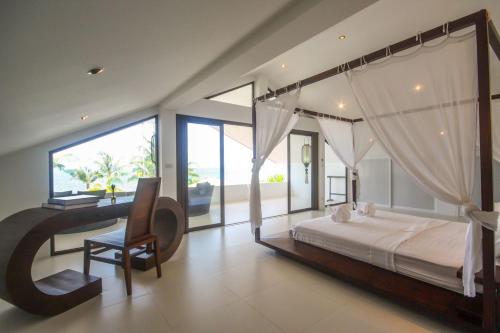 a bedroom with a large bed and a desk and chair at Malee Beach A4 in Ko Lanta