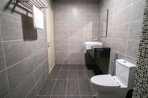 a bathroom with a toilet and a sink at Revo Pavilion Bukit Jalil by Ody Suites in Kuala Lumpur