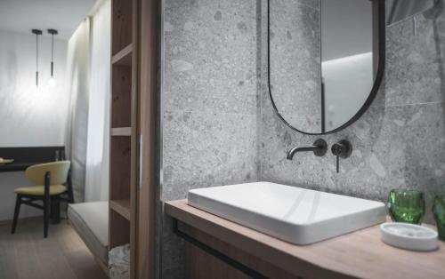 a bathroom with a sink and a bath tub at Kronplatz-Resort Hotel Kristall in Valdaora