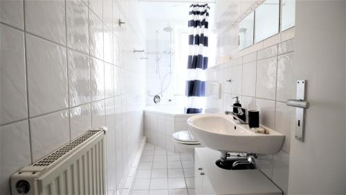 a white bathroom with a sink and a toilet at Zentral Wohnen - inkl. privatem Stellplatz in Würzburg