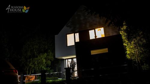 a house at night with the lights on at 4 Seasons - House in Sub Cetate