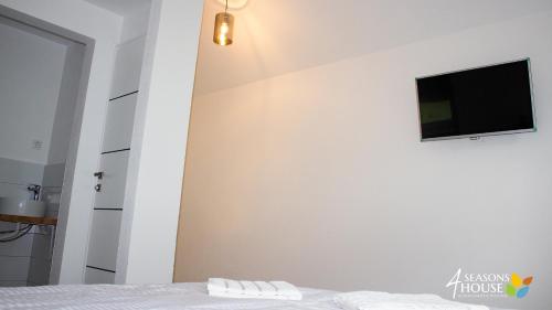 a bedroom with a bed and a tv on a wall at 4 Seasons - House in Sub Cetate