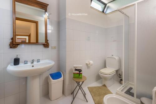 a bathroom with a sink and a toilet and a mirror at Eden Charming House in Avola
