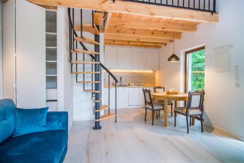 a kitchen and dining room with a spiral staircase in a tiny house at Kameralny domek Kazimierzówka in Kazimierz Dolny