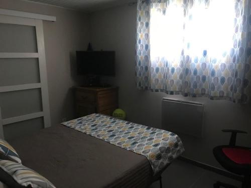 une petite chambre avec un lit et une fenêtre dans l'établissement LE CARABIOL - Chambre d'Hôte, à Saint Julien Les Rosiers