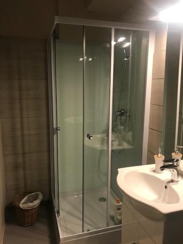 une salle de bain avec une douche en verre et un lavabo dans l'établissement LE CARABIOL - Chambre d'Hôte, à Saint Julien Les Rosiers