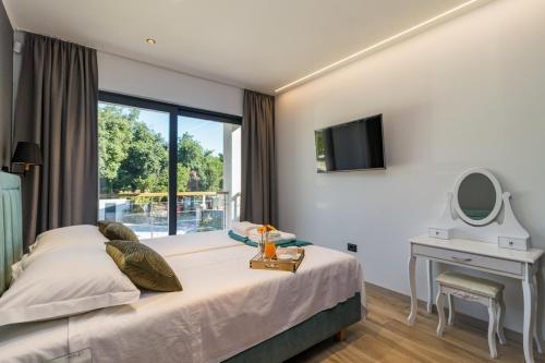 a bedroom with a bed and a desk with a mirror at Villa Munat in Ližnjan