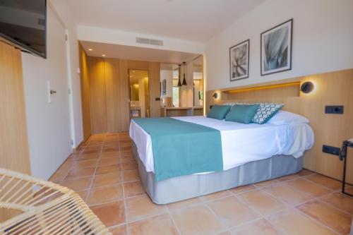 a bedroom with a large bed and a kitchen at Mon Port Hotel & Spa in Port d’Andratx