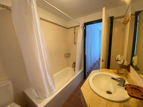 ein Badezimmer mit einem Waschbecken, einer Badewanne und einem WC in der Unterkunft ES BERRY 3 by SOM Menorca in Fornells