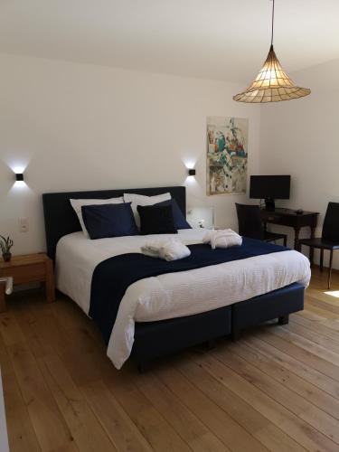 - une chambre avec un grand lit et des oreillers bleus dans l'établissement Elingenhof, à Elingen