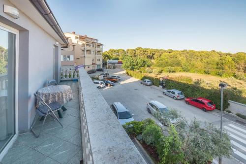 a balcony with a table and a view of a parking lot at Apartman, studio and room Kata in Pula