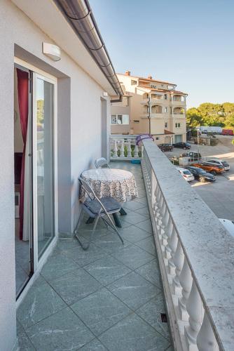 a balcony with a table and chair on a building at Apartman, studio and room Kata in Pula