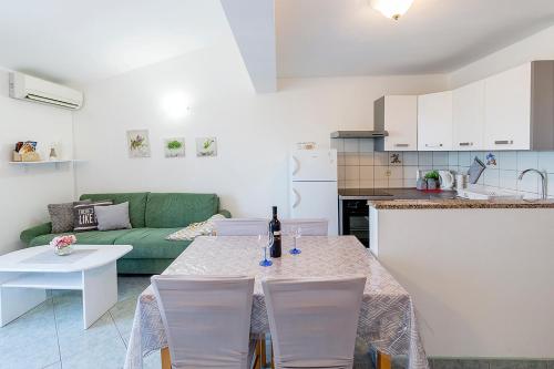 a living room with a table and a green couch at Apartman, studio and room Kata in Pula