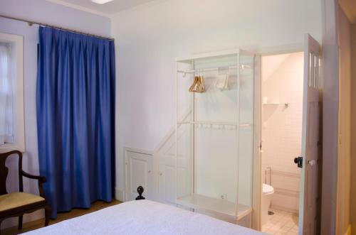 1 dormitorio con ducha de cristal y cortina azul en Porto.arte downtown apartment, en Oporto