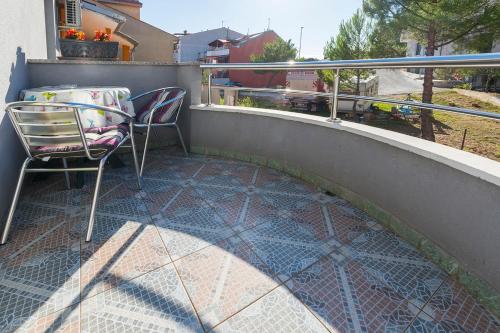 a patio with a chair and a table on a balcony at Apartman, studio and room Kata in Pula